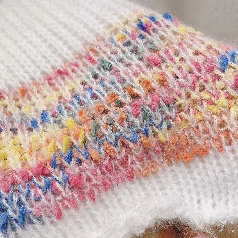 Elegant, loose white sweater with puff sleeves and colorful horizontal stripes