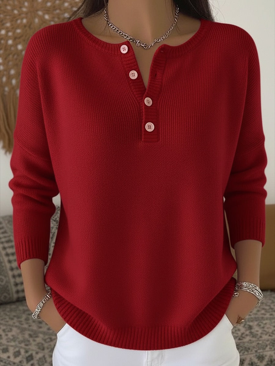 Elegant and comfortable sweater in carmine red with decorative buttons at the neckline