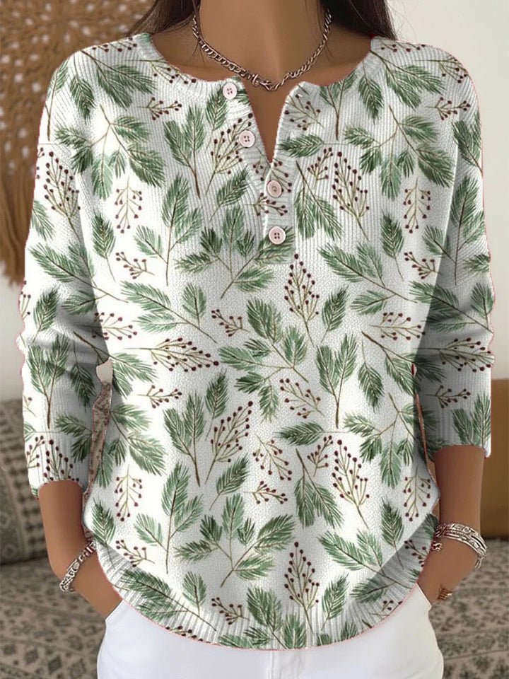 Elegant and comfortable sweater with a pattern of green leaves and decorative buttons at the neckline