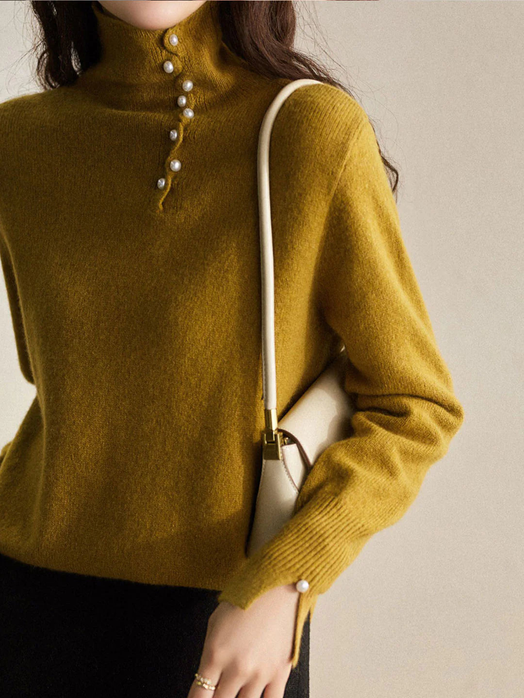 Simple and comfortable women's sweater with a turtleneck, adorned with pearl buttons at the collar