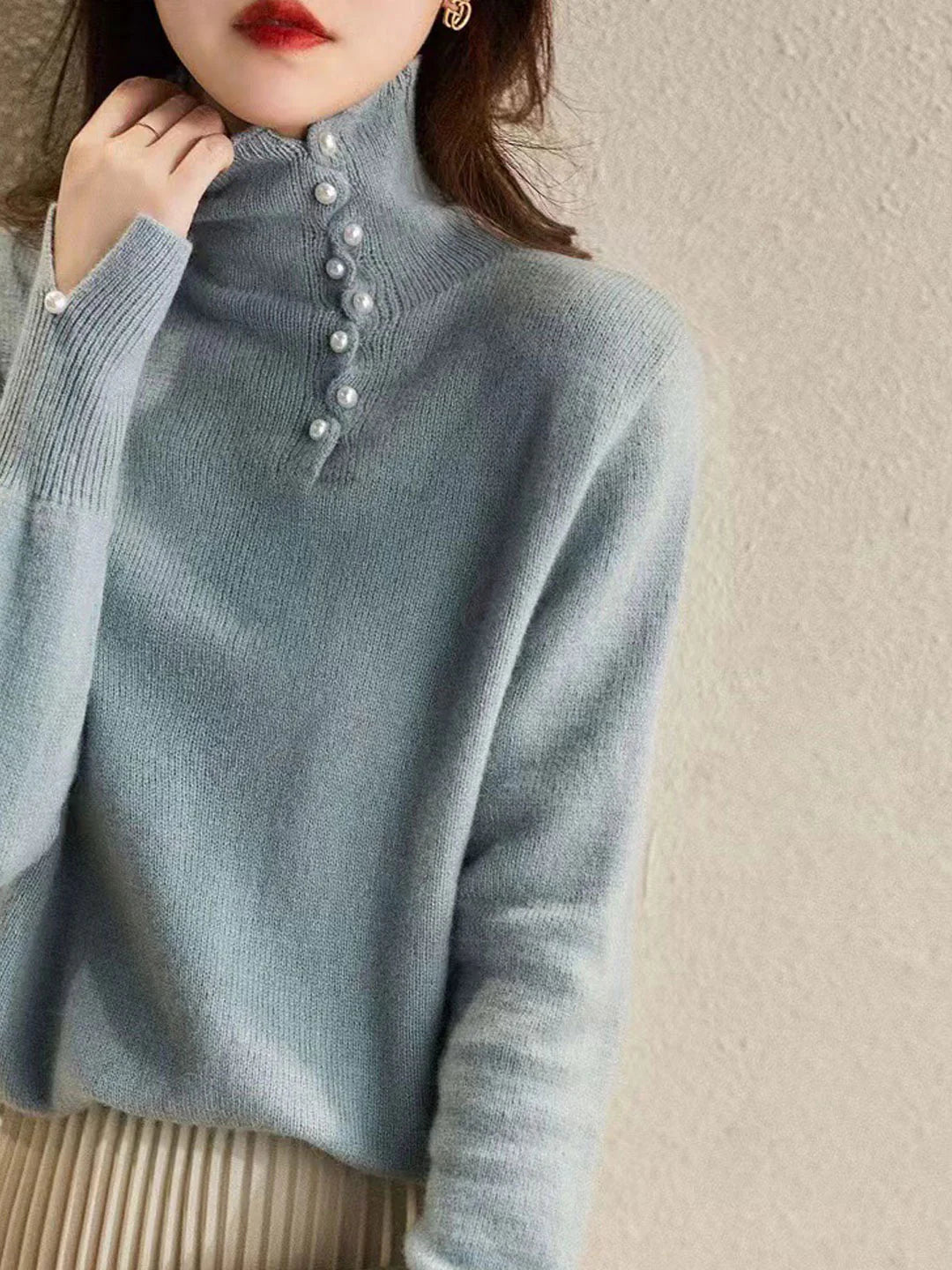 Simple and comfortable women's sweater with a turtleneck, adorned with pearl buttons at the collar