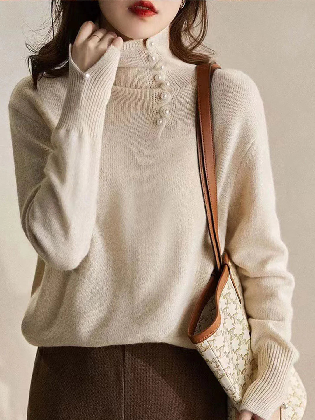 Simple and comfortable women's sweater with a turtleneck, adorned with pearl buttons at the collar