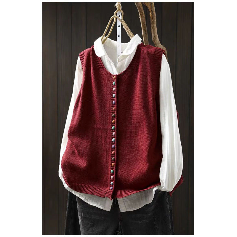 Loose, universal sleeveless sweater-vest in a solid color with colorful buttons