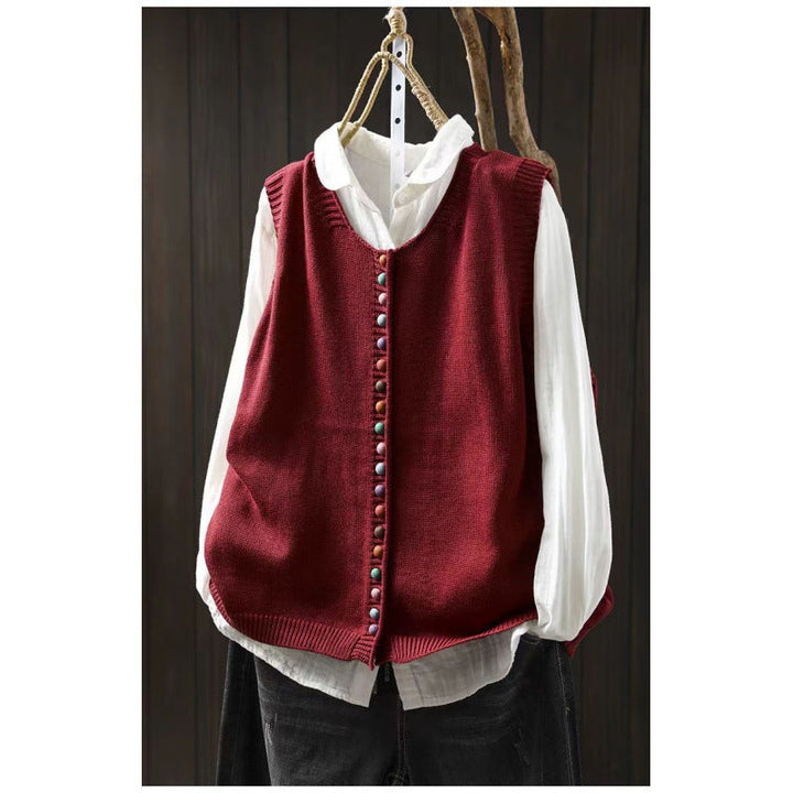 Loose, universal sleeveless sweater-vest in a solid color with colorful buttons