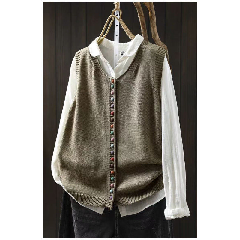Loose, universal sleeveless sweater-vest in a solid color with colorful buttons