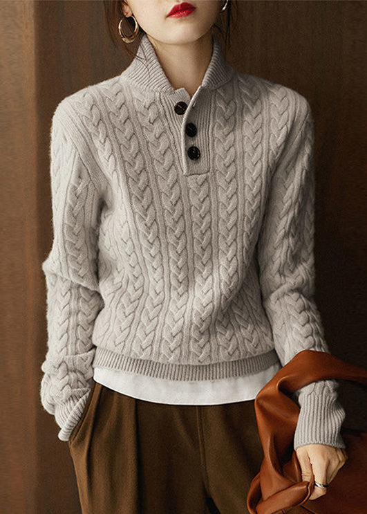 Simple and comfortable women's sweater made of thick knit, in a solid color, with a stand-up collar and buttons